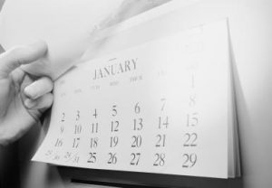 Hand opening calendar showing January