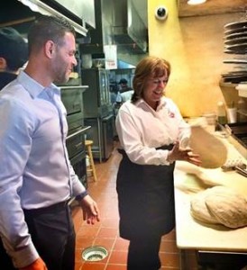 Lynda Bell tosses dough at Sal's Italian Restaurant -- while a photographer stands ready to capture every spin.